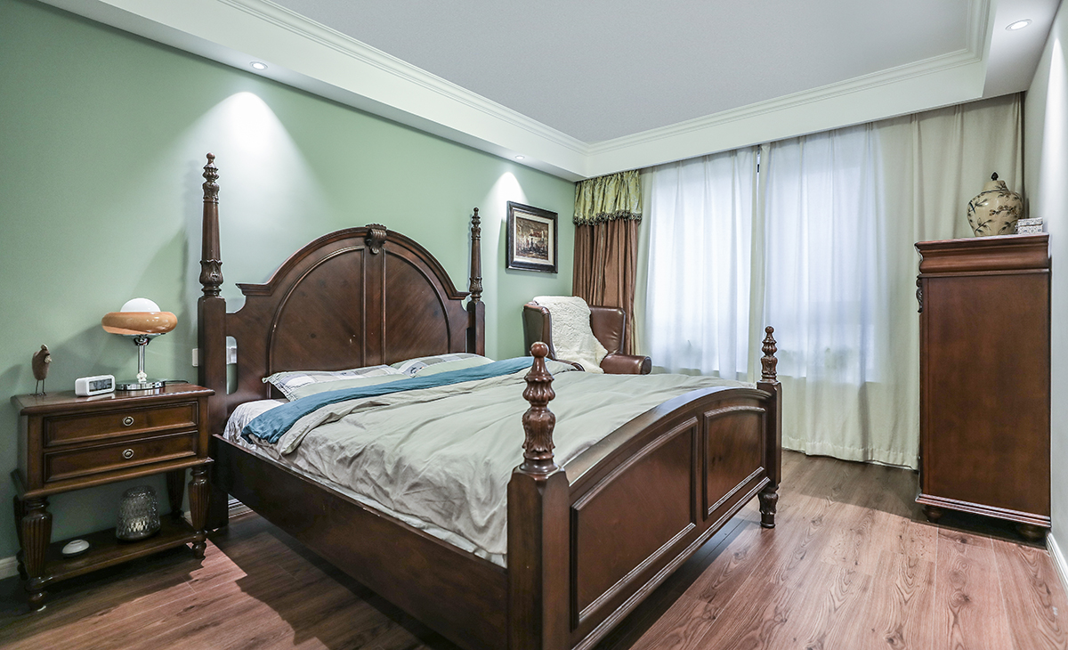 主卧床头背景浅绿色，地面用胡桃色，L型大飘窗让卧室空间具有延伸感，射灯把整个空间点缀地丰富、有质感