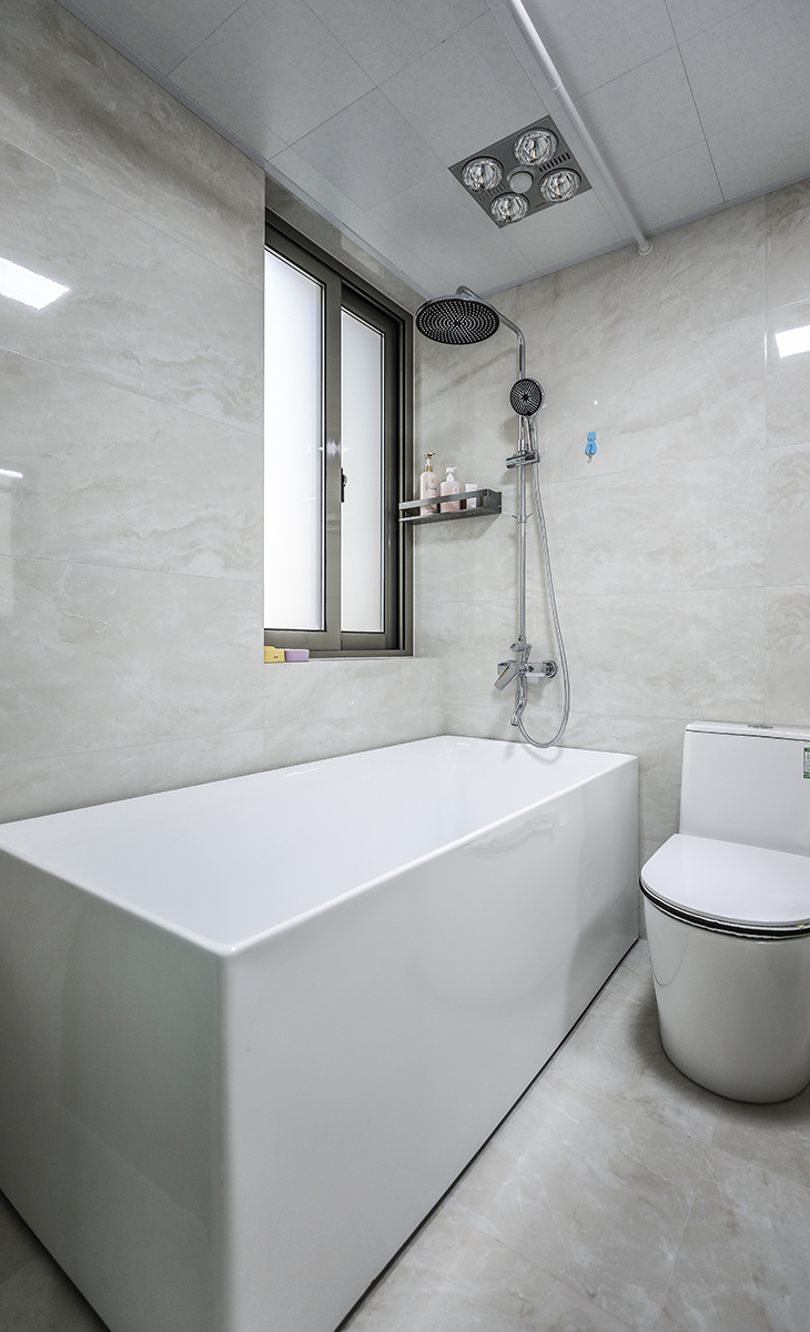 卫生间空间很大，放一个浴缸可以随时随地的泡澡，水质也干净。地面暖灰色墙地砖，白色吊顶，钛合金移门，配上马桶和毛巾架，更加合理的卫浴空间。