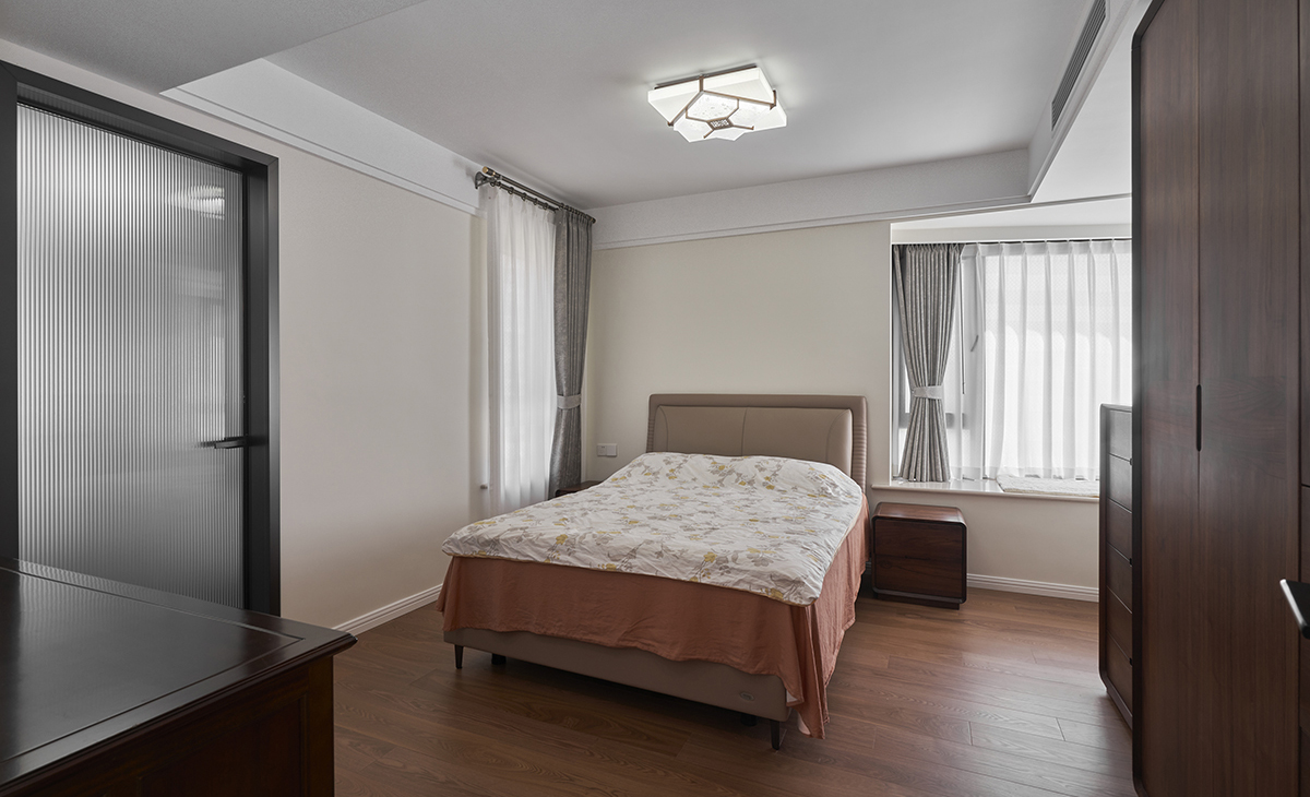 主卧床头背景纯色，地面用胡桃色，L型大飘窗让卧室空间具有延伸感，射灯把整个空间点缀地丰富、有质感