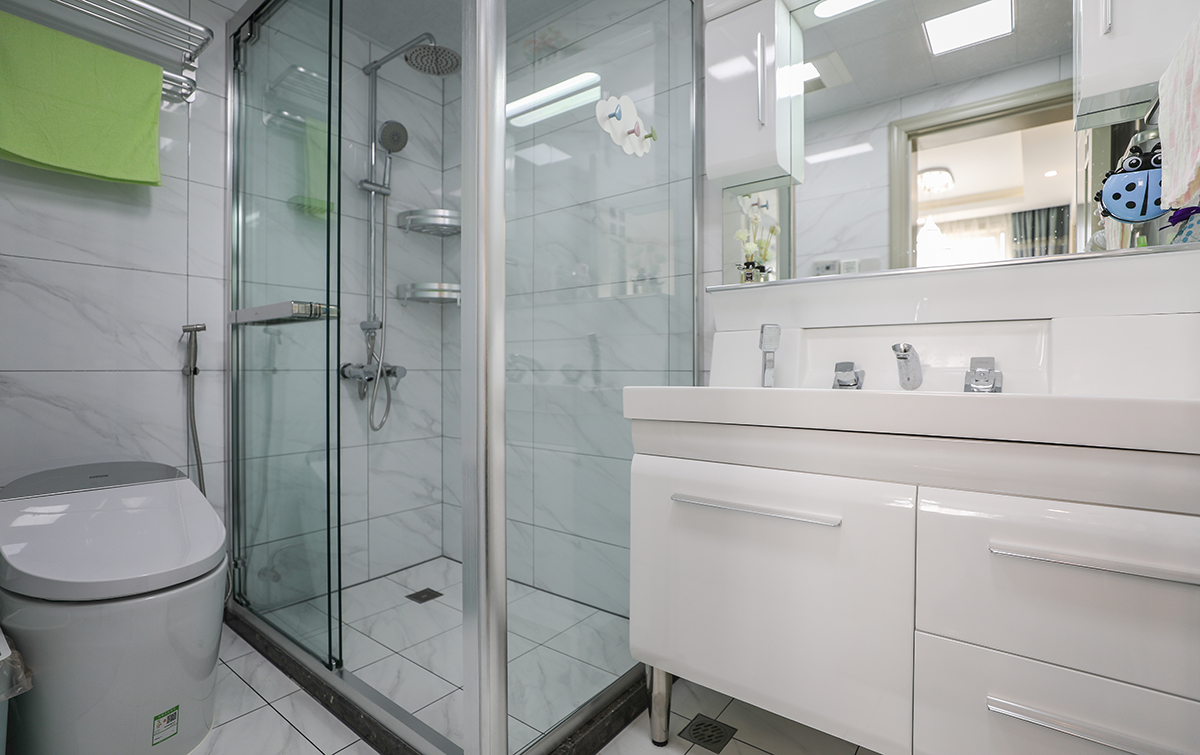 长方形淋浴房，充足的淋浴空间。白色的瓷砖空间明亮。合理的马桶台盆柜位置摆放动线更为合理，区域划分鲜明互不干涉。

